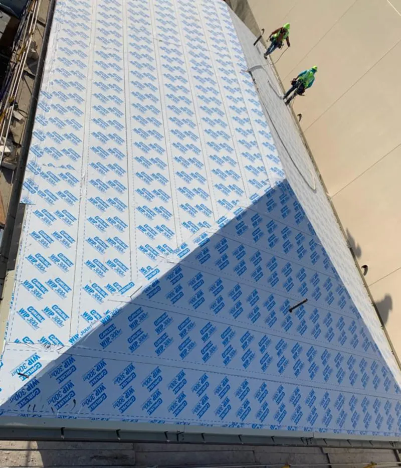 Professional roofers installing underlayment on a metal roof in Little Egg Harbor